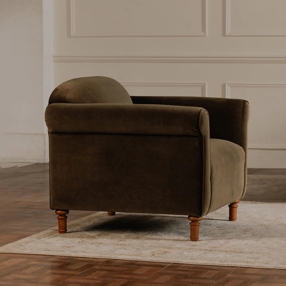 Luxury velvet deep olive armchair in a room with wooden flooring and beige walls