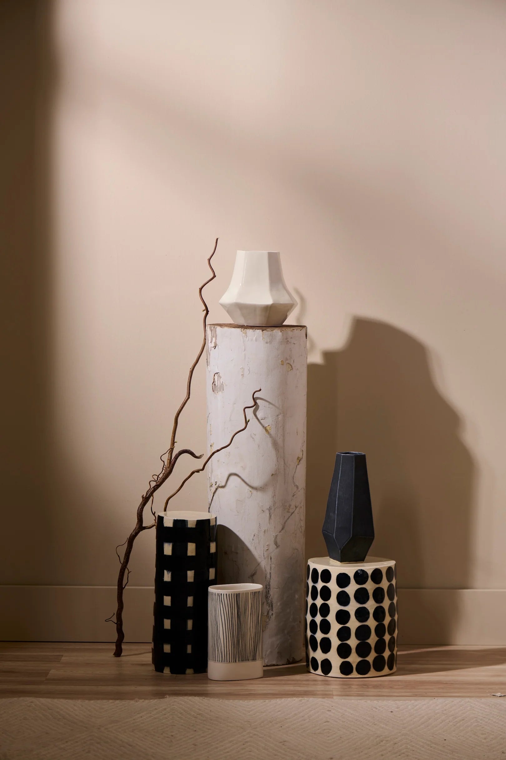 Vases and a candle on a wooden surface with a neutral background highend sculpture by Lauren HB Studio